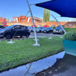 Vista general del estacionamiento de la UMAD cubierto de charcos y con el suelo de grava deteriorado por las lluvias.