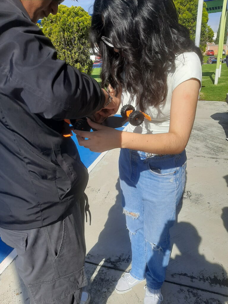 Dos universitarios ajustan las ligas de su carrito antes de lanzarlo.