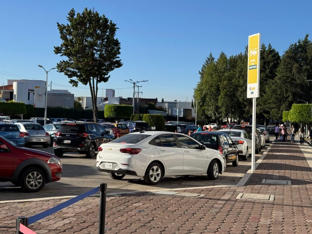 Varios autos avanzan lentamente dentro del campus de la Universidad Madero, mientras los conductores esperan bajar a los estudiantes.