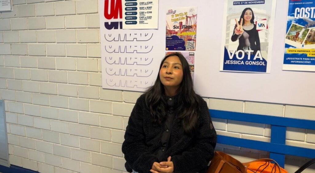 Estudiante de la UMAD frente a carteles de la simulación electoral universitaria, un caso de desconocimiento del evento