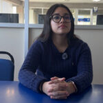 Jessica González sentada frente a una mesa azul durante una entrevista, exponiendo ideas sobre cómo fortalecer seguridad en la UMAD.