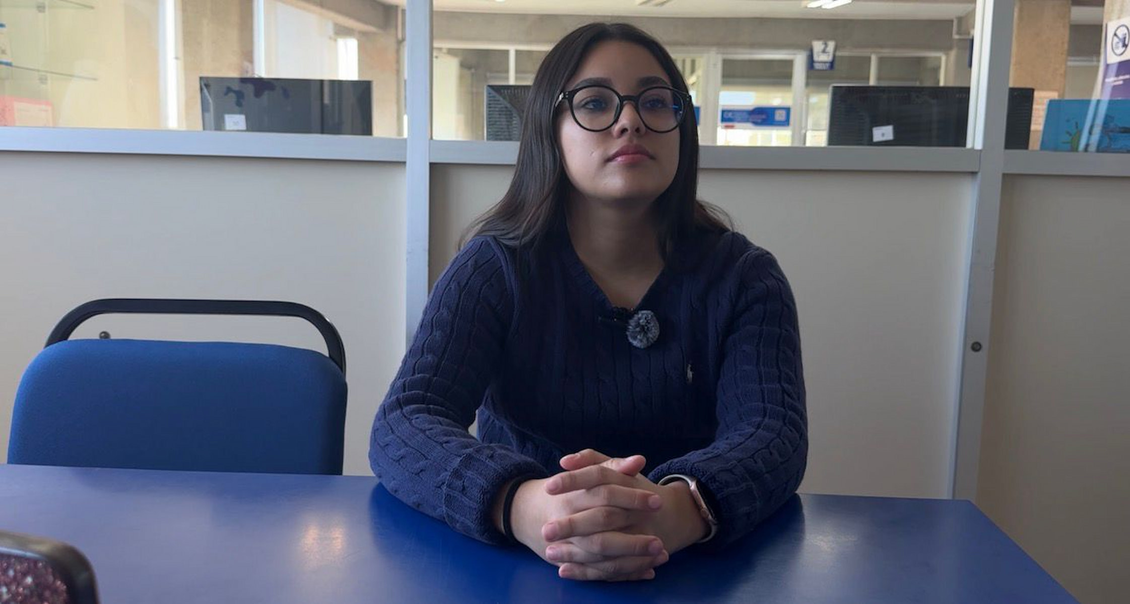Jessica González sentada frente a una mesa azul durante una entrevista, exponiendo ideas sobre cómo fortalecer seguridad en la UMAD.